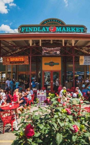 A busy findlay market with people sitting at tables and eating